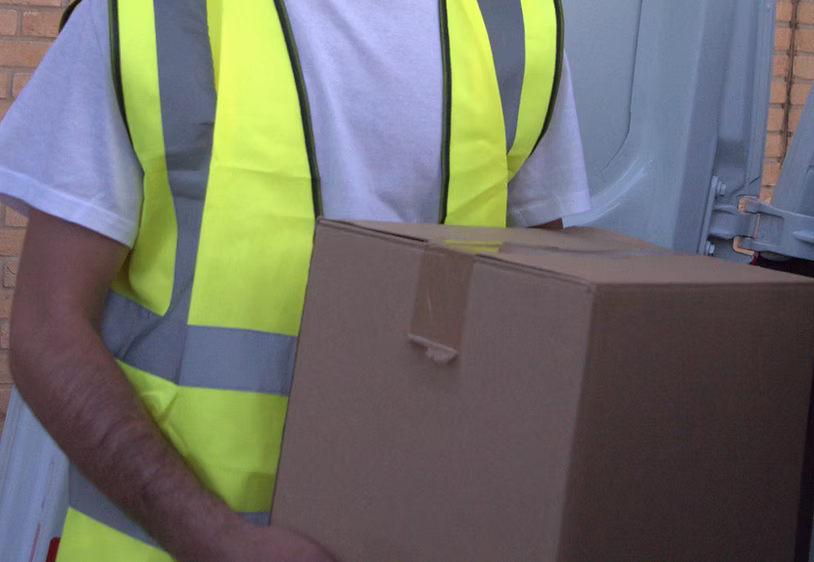 Driver in hi-vis vest carrying a parcel